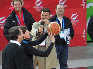 IOC Member Claudia Bokel tries a free-throw at Atakoy Dome in Istanbul as Bid Chief Hasan Arat (left) looks on (GamesBids Photo)